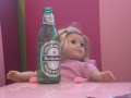 Kit as a doll. Notice the bottle of beer in front of her.